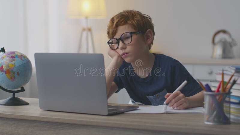 Langweilige Online-Bildung. müde Rotschopf Junge sehen Webinar oder Video-Lektion zu Hause mit Blick auf Laptop und Gefühl müde stock video