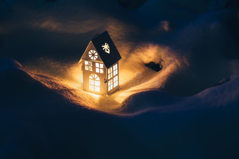 Lantern House with Burning Candle on Snow in the Evening Stock Photo
