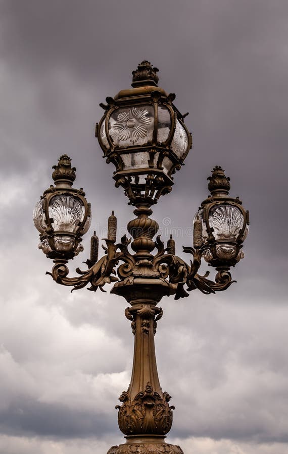 Lanterna da rua na ponte de Alexandre III contra o céu nebuloso imagens de stock Lanterna da rua na ponte de Alexandre III contra o céu nebuloso imagens de stock