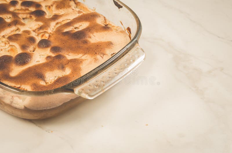 Lantlig bundtkaka med äpplet/den lantliga bundtkakan med äpplet i en exponeringsglaspalett på en marmortabell, kopieringsutrymme royaltyfri fotografi Lantlig bundtkaka med äpplet/den lantliga bundtkakan med äpplet i en exponeringsglaspalett på en marmortabell, kopieringsutrymme royaltyfri fotografi