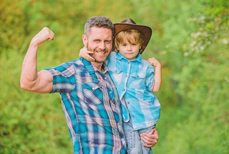 Lantlig familj V?xande gullig cowboy Liten hj?lpreda i tr?dg?rd Pys och fader i naturbakgrund Ande av fotografering för bildbyråer Lantlig familj V?xande gullig cowboy Liten hj?lpreda i tr?dg?rd Pys och fader i naturbakgrund Ande av fotografering för bildbyråer