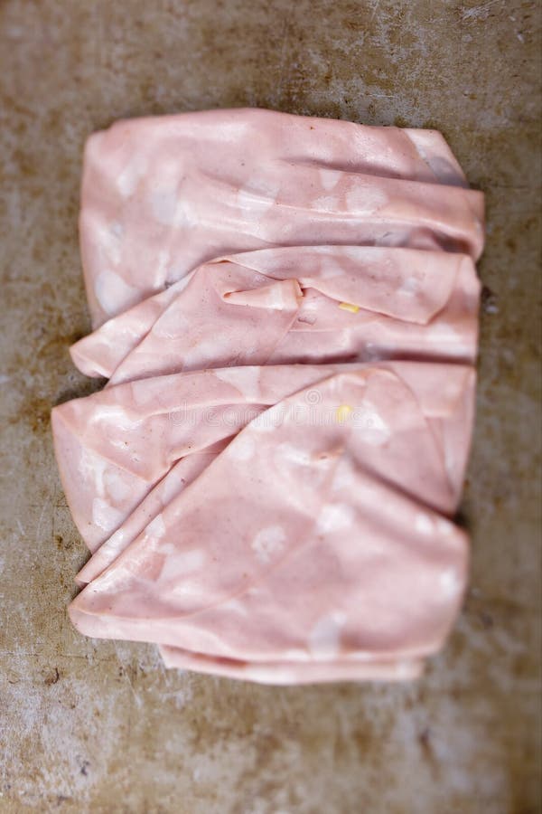Lantlig italiensk defocused skivad suddighet för mortadella korv arkivbilder Lantlig italiensk defocused skivad suddighet för mortadella korv arkivbilder