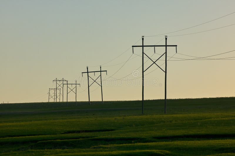 Lantlig plats med elektricitetspyloner på solnedgången arkivfoton Lantlig plats med elektricitetspyloner på solnedgången arkivfoton