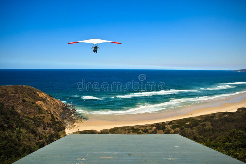 Lançamentos do planador de cair do monte acima da praia