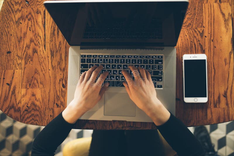 Lap-top υπολογιστών χρήσης γυναικών χεριών στον καφέ στοκ εικόνα Lap-top υπολογιστών χρήσης γυναικών χεριών στον καφέ στοκ εικόνα