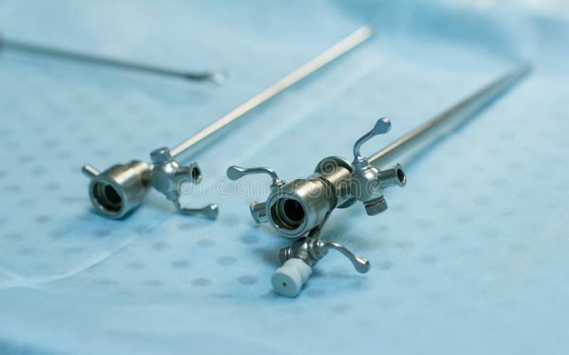 The Laparoscopic Instrument Lies on the Table in Surgery on a Blue Background. Tubes for