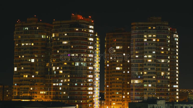 Lapso de tiempo de una ciudad por la noche. luz en las ventanas de los edificios residenciales de varios pisos. la vida en una gra