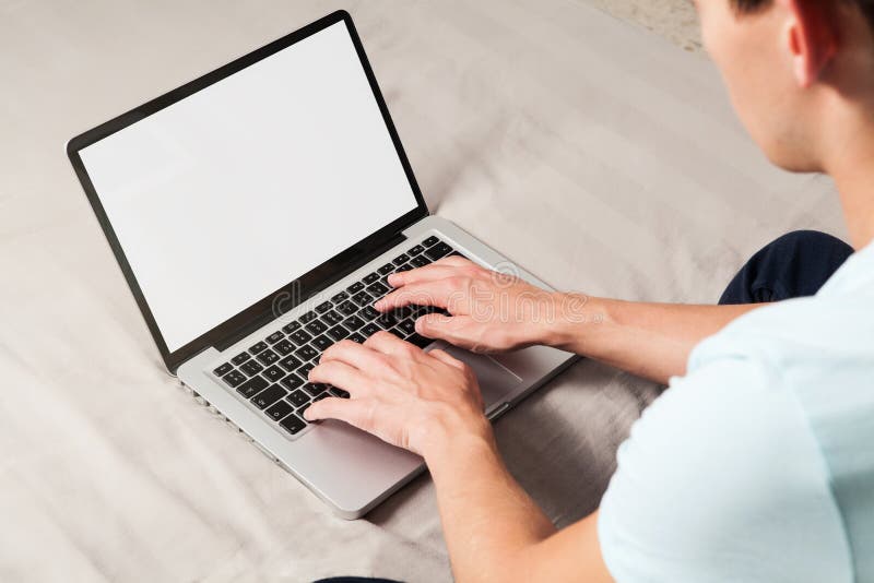 Laptop-Computer mit weißem leerem Bildschirm und jungem Mann unter Verwendung er stockfotografie Laptop-Computer mit weißem leerem Bildschirm und jungem Mann unter Verwendung er stockfotografie