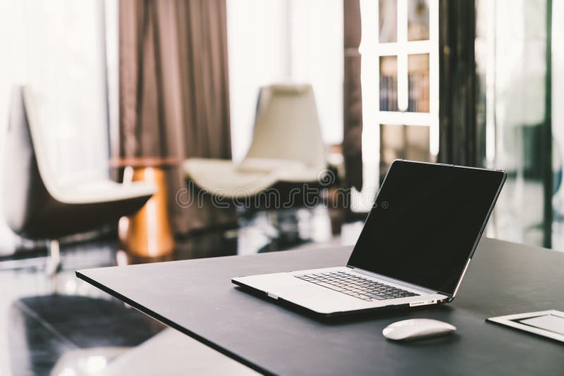 Laptop computer on work table in modern luxury contemporary office. Corporate business, internet information technology, or freelance job working at home concept. Laptop computer on work table in modern luxury contemporary office. Corporate business, internet information technology, or freelance job working at home concept