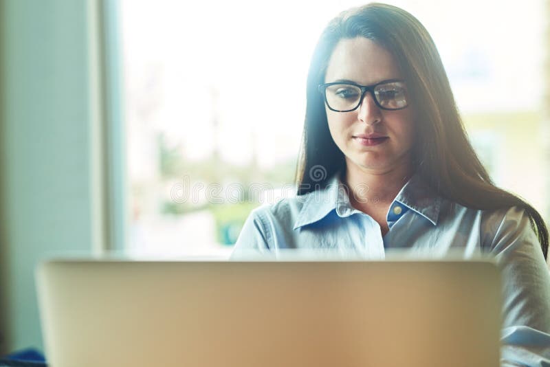 Laptop femminile e occhiali al bar per la scrittura di e-mail da scrittore freelance e per la ricerca di articoli. donna immagine stock libera da diritti