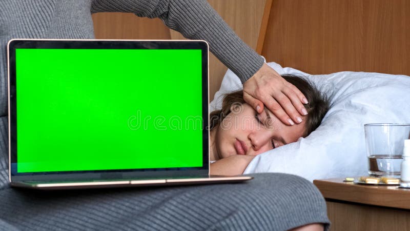 Laptop green screen mock up, mother with sick child girl, lying on bed, on background. Empty blank display template royalty free stock photos