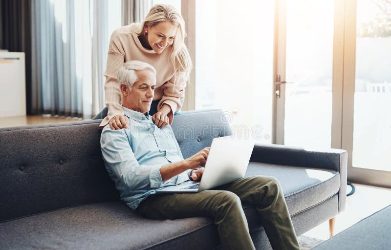 Laptop, internet and mature couple on couch with asset management research, planning and investment in home. Lounge stock image