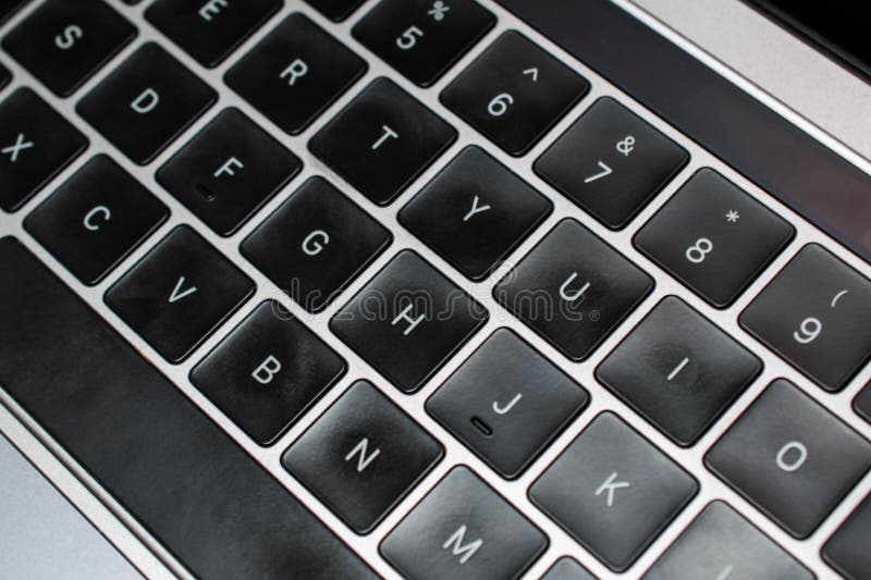 Closeup of a laptop keyboard with black letters and numbers on it. A laptop keyboard is a compact, integrated input device found on laptops and notebooks, consisting of a set of keys for typing and controlling various functions of the computer.