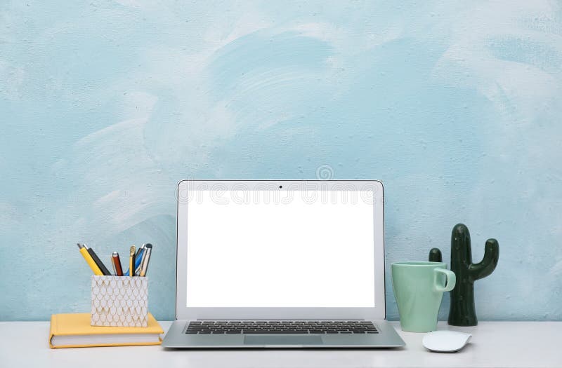 Laptop na biurku przeciw kolor ścianie w ministerstwie spraw wewnętrznych fotografia stock Laptop na biurku przeciw kolor ścianie w ministerstwie spraw wewnętrznych fotografia stock