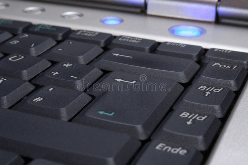 Laptop's keyboard with blue on-button stock photo