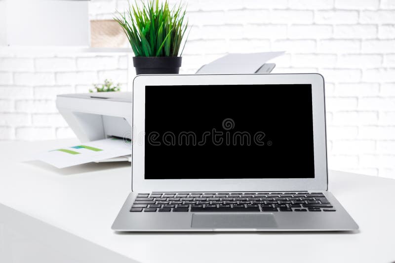 Laptop and printer on white office desk with office supplies. Laptop and printer on white office desk with office supplies