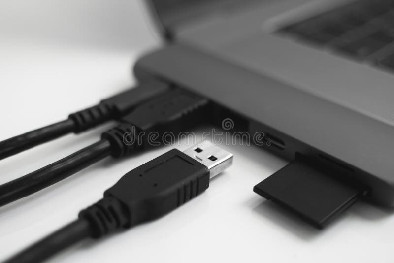 Laptop with USB Type-C adapter with pluged USB cables and SD card. The USB adapter under the Type-C connector for laptop