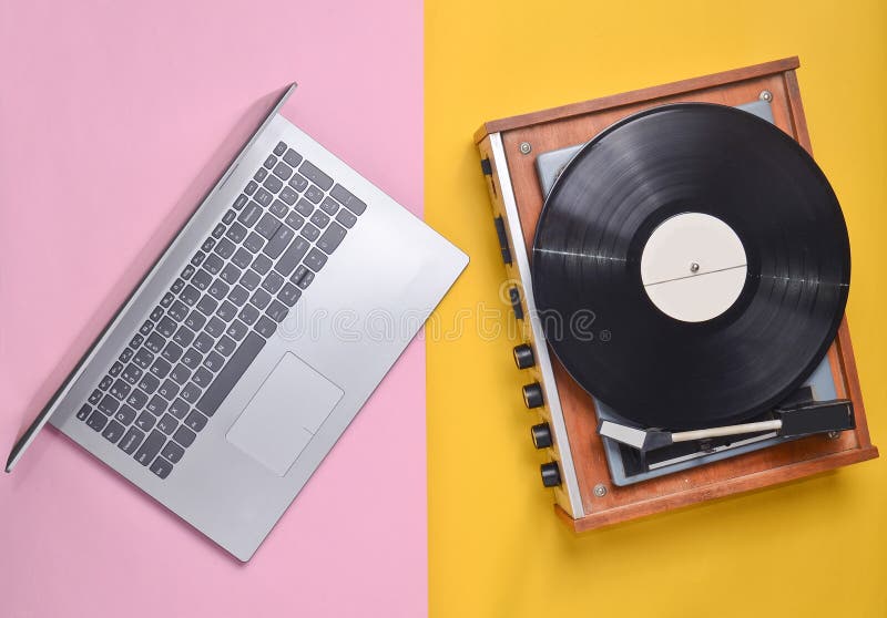 Laptop, vinyl player on a colored pastel background. Modern and outdated technology, top view. royalty free stock photography Laptop, vinyl player on a colored pastel background. Modern and outdated technology, top view. royalty free stock photography