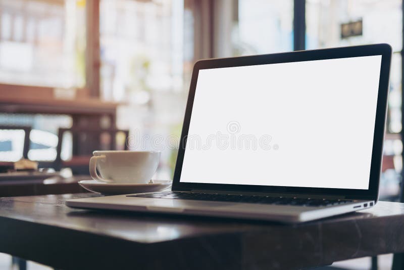 Mockup image of laptop with blank white screen on wooden table in modern loft cafe. Mockup image of laptop with blank white screen on wooden table in modern loft cafe