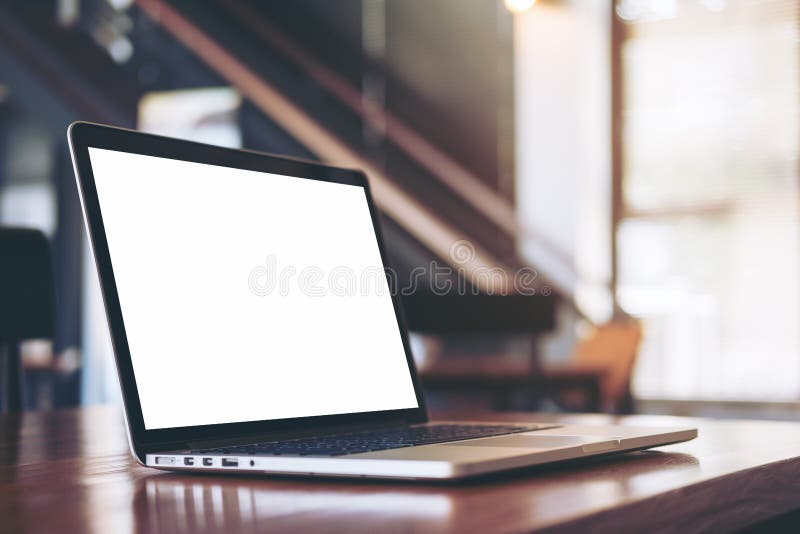 Mockup image of laptop with blank white screen on wooden table in modern loft cafe. Mockup image of laptop with blank white screen on wooden table in modern loft cafe