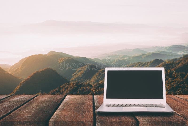 Laptop z pustym ekranem na drewnianym stole z lasem w górze zdjęcie royalty free Laptop z pustym ekranem na drewnianym stole z lasem w górze zdjęcie royalty free