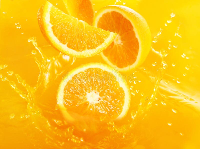 Laranjas frescas que caem no suco imagem de stock royalty free Laranjas frescas que caem no suco imagem de stock royalty free