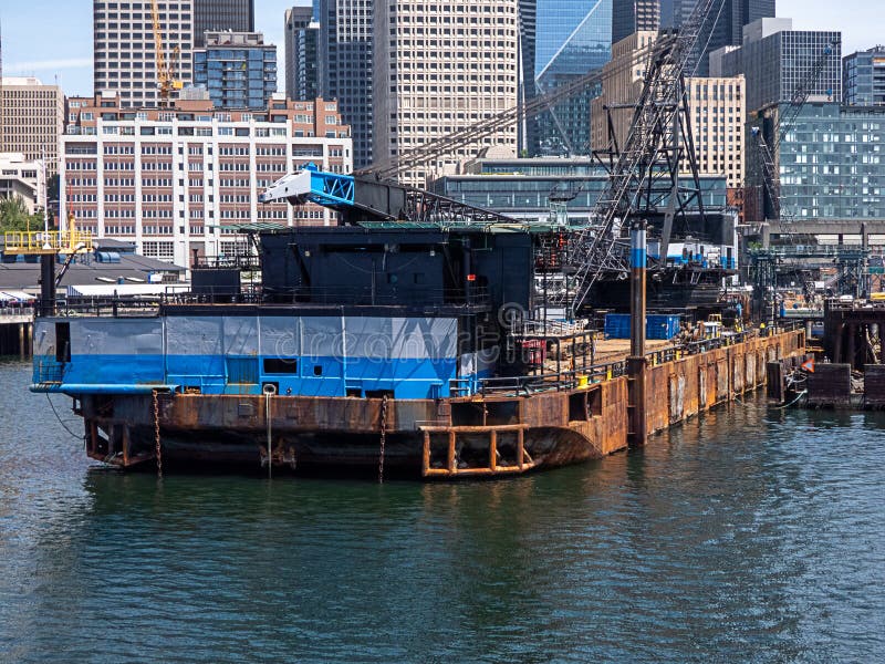 Large barge with construction equiptment and crane along the shores of city stock images Large barge with construction equiptment and crane along the shores of city stock images