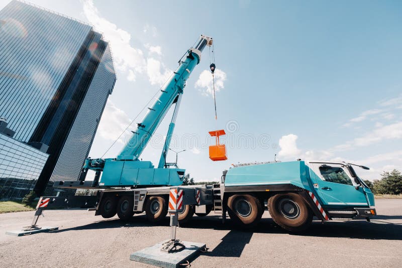 A Large Blue Truck Crane Stands Ready for Operation on a Site Near a