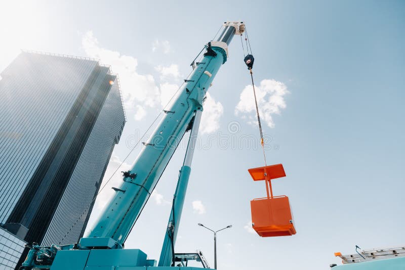 A Large Blue Truck Crane Stands Ready for Operation on a Site Near a