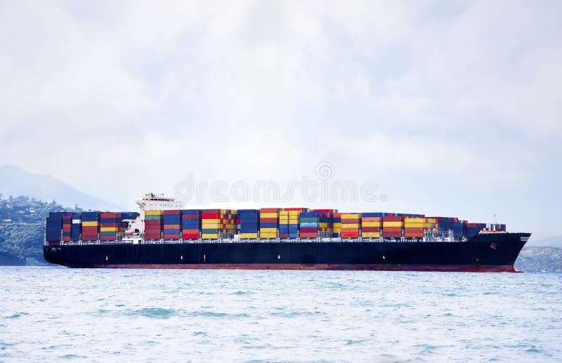 Large cargo ship in water carrying colorful shipping containers. Large cargo ship in water carrying colorful shipping containers