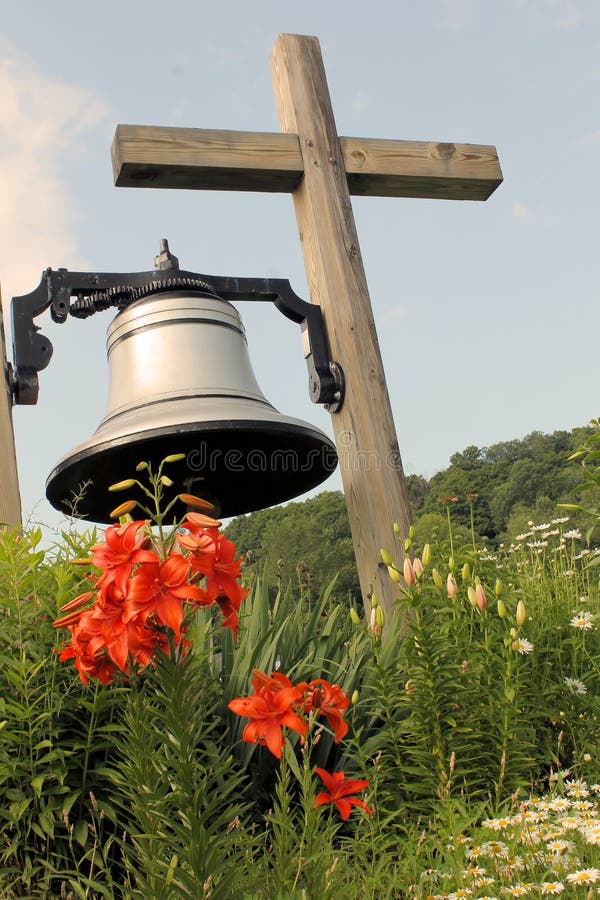 Large bell hanging from wooden cross in front of a newly restored historic church in Morrisville, New York. Large bell hanging from wooden cross in front of a newly restored historic church in Morrisville, New York