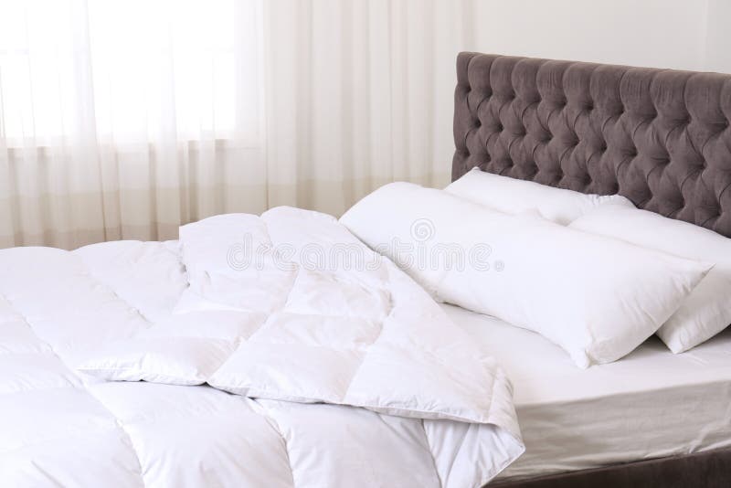 Large Comfortable Bed with Pillows and Blanket Near Window Indoors