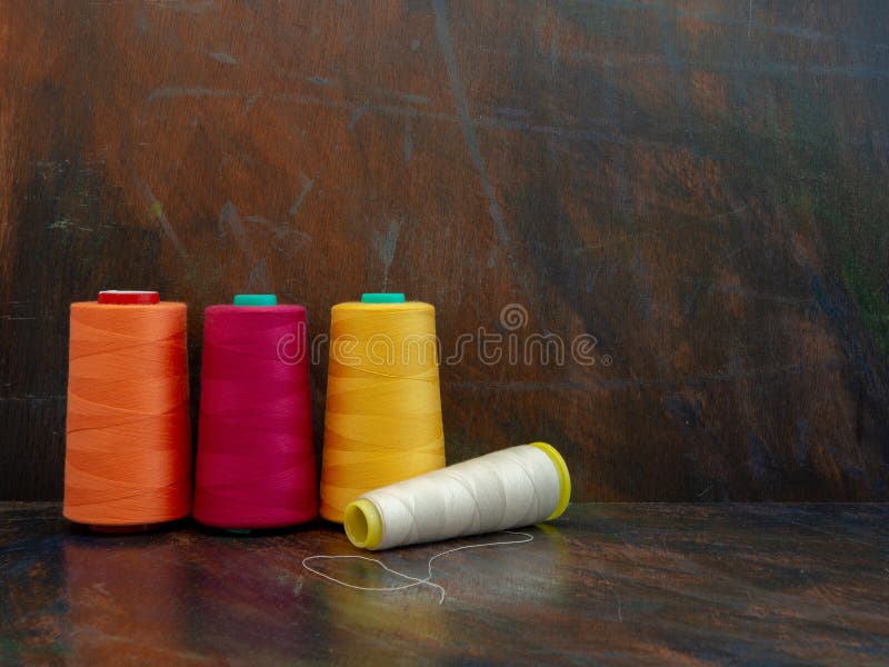 Professional industrial cones of colorful sewing threads laying and standing on a dark background. Front view studio shot. royalty free stock photo Professional industrial cones of colorful sewing threads laying and standing on a dark background. Front view studio shot. royalty free stock photo