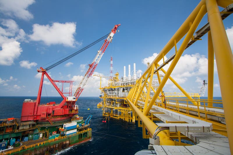 Large crane vessel installing the platform in offshore, crane barge doing marine heavy lift installation works stock photo Large crane vessel installing the platform in offshore, crane barge doing marine heavy lift installation works stock photo