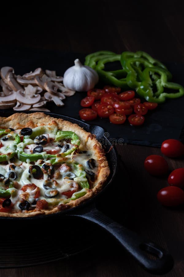 Large Deep Dish Deluxe Pan Pizza Ready for Serving, Against a Dark