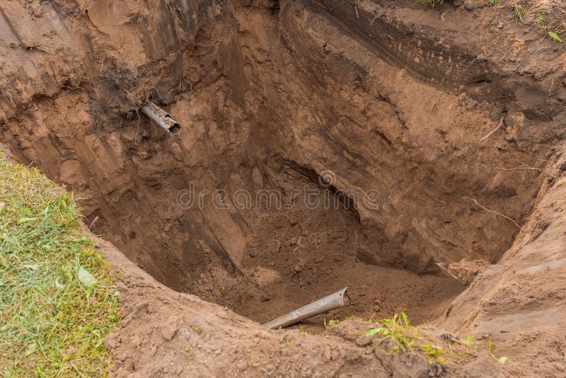 Large Deep Pit in the Ground after Digging an Excavator Sewer Pipe in