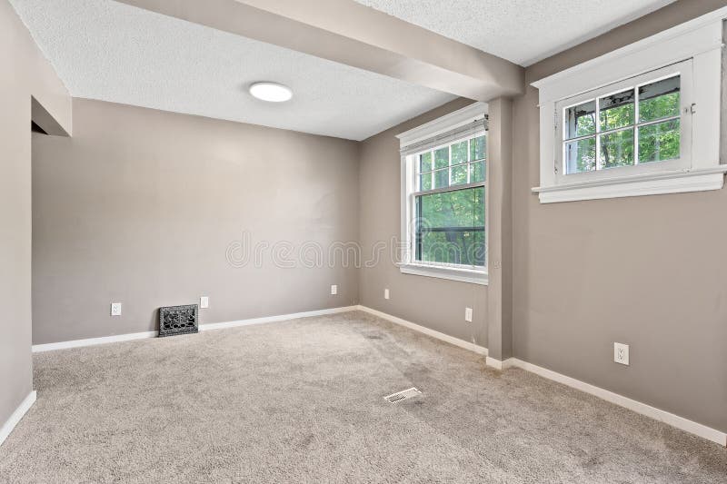 Large, empty room with a tan wall and a white ceiling royalty free stock image