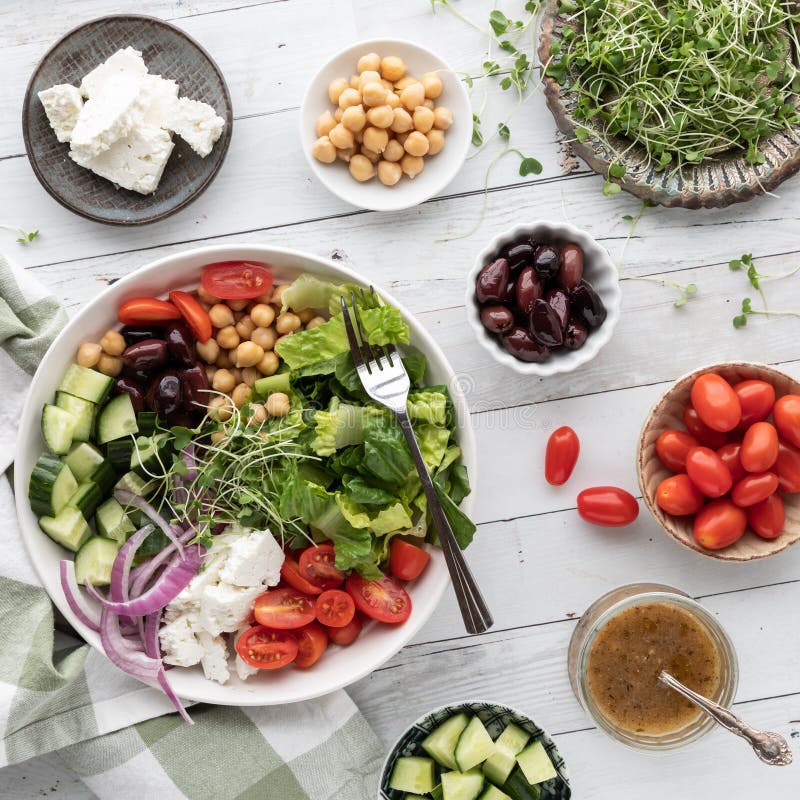 A Large Fresh Greek Salad Bowl with Ingredients in Smaller Bowls ...