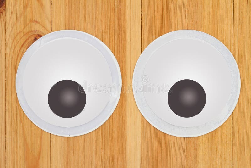 Large Googly Eyes on a Wood Desk Stock Photo - Image of view