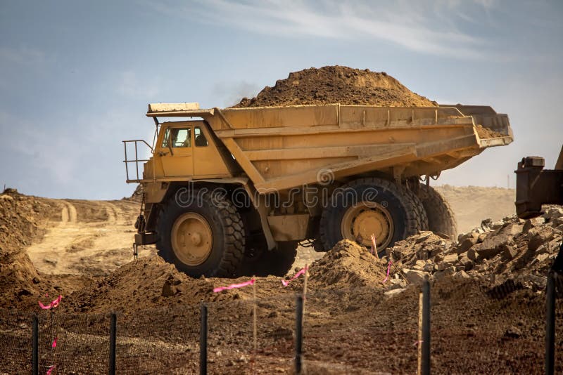 A Very Large Haul Dump Truck at a Construction Site with a Worker