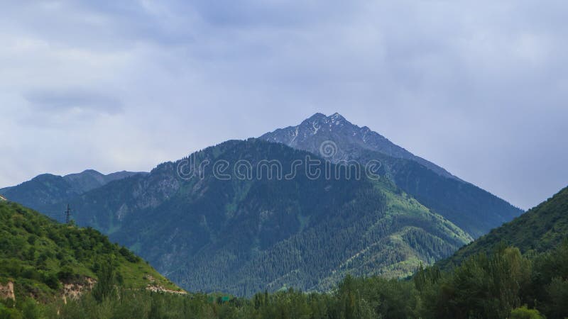 A large and high mountain is seen in the distance among the slopes of the mountains.