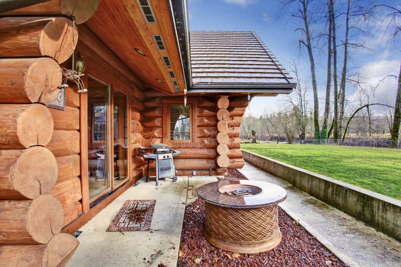 Large log cabin house exterior with patio area.