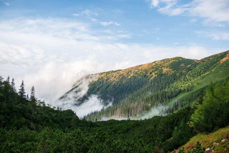 Veľký hmlový oblak stúpajúci horskou dolinou na slovensku, Tatry