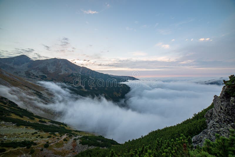 Large misty cloud climbing mountain valley in slovakia, Tatra