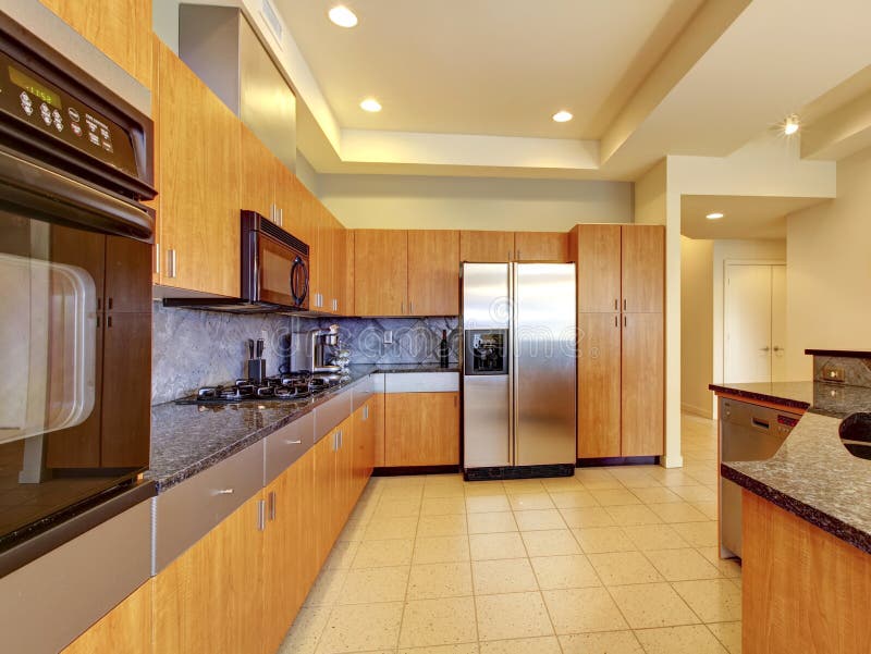 Large modern wood kitchen with living room and high ceiling.