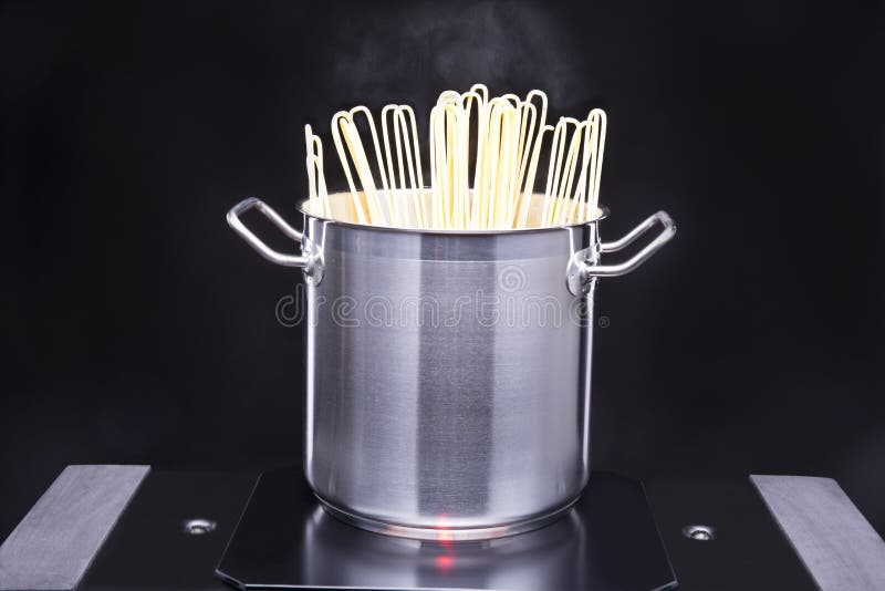 Pasta sticking out of the pan on the hob. Traditional big metal pot stock images, royalty-free photos and pictures