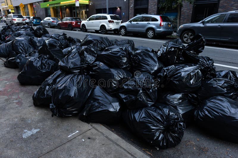 Black Trash Bags Along A Street And Sidewalk In Greenwich Village