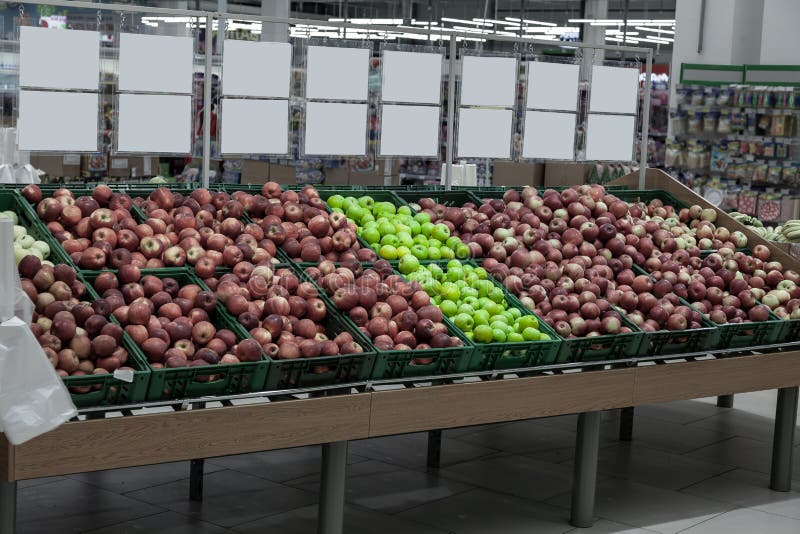 A large rack with baskets with different types of apples in the fruit department of the shopping center. Fresh and healthy foods f royalty free stock photos A large rack with baskets with different types of apples in the fruit department of the shopping center. Fresh and healthy foods f royalty free stock photos