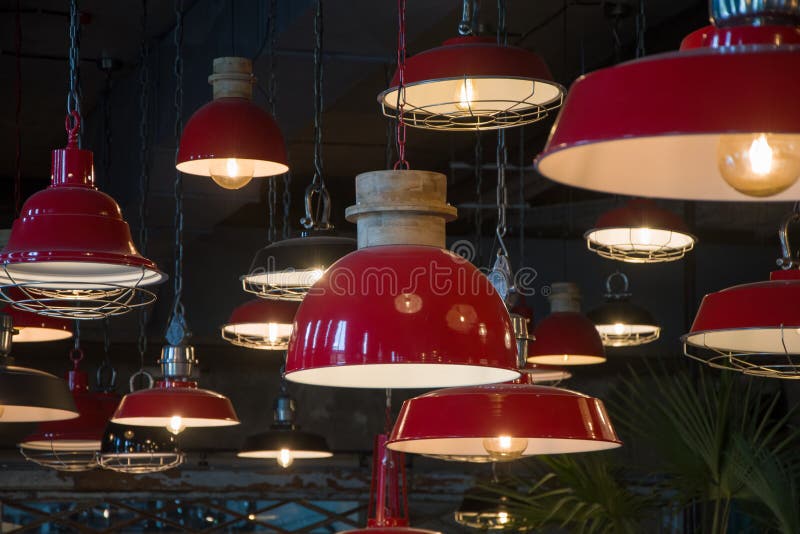 Large Red Metal Chandeliers In The Form Of Pots Hang From The