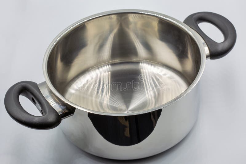 Studio shoot of large shiny stainless steel empty new saucepan closeup on white. Traditional big metal pot stock images, royalty-free photos and pictures
